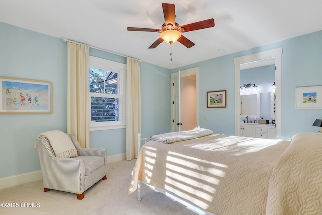 bedroom featuring ceiling fan, ensuite bath, and light carpet