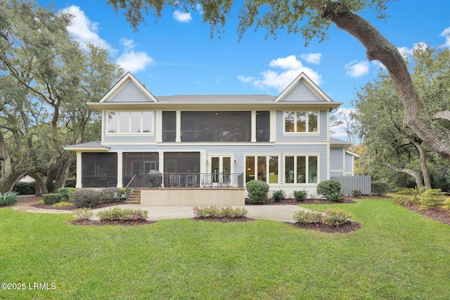 back of property with a sunroom and a lawn