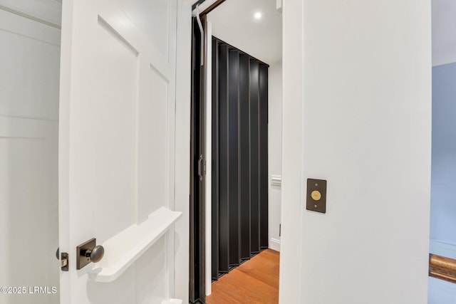 hallway with hardwood / wood-style flooring