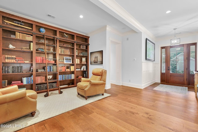 sitting room featuring crown molding and light hardwood / wood-style flooring