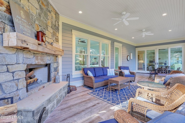 living room featuring ornamental molding, plenty of natural light, hardwood / wood-style floors, and an outdoor stone fireplace