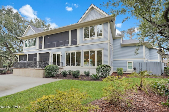 back of property with a patio, a sunroom, and a yard