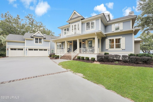 view of front of property with a garage, a front yard, and covered porch