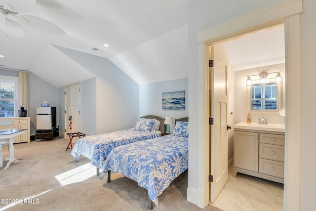 carpeted bedroom with sink, ensuite bath, vaulted ceiling, and ceiling fan