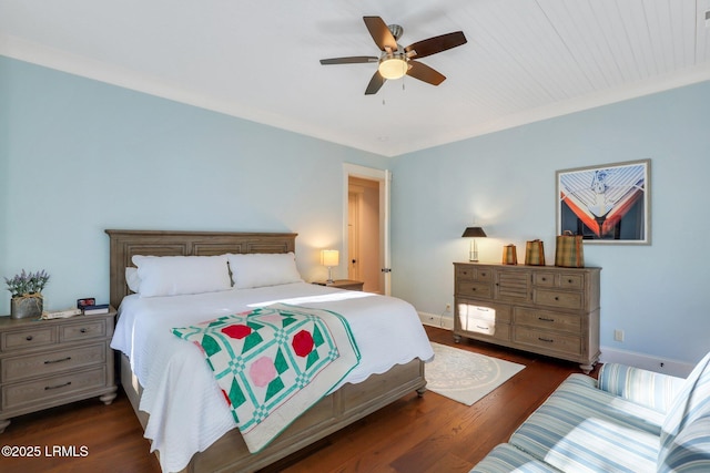 bedroom featuring crown molding, dark wood-type flooring, and ceiling fan