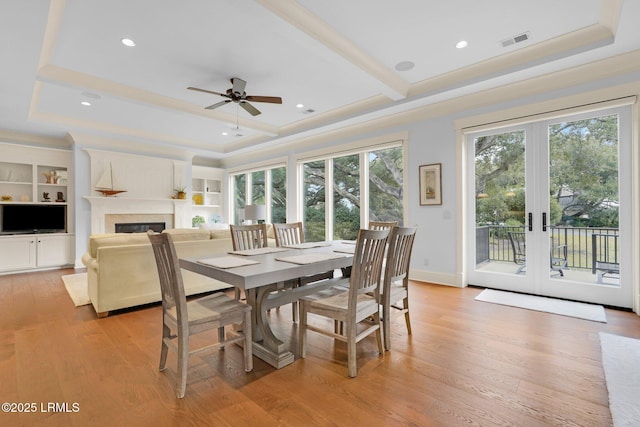 dining space featuring built in shelves, light hardwood / wood-style floors, french doors, and ceiling fan