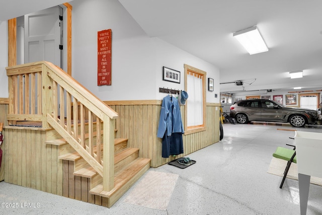 stairway featuring wood walls