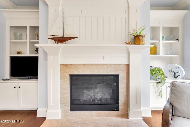 details with hardwood / wood-style floors and a tile fireplace