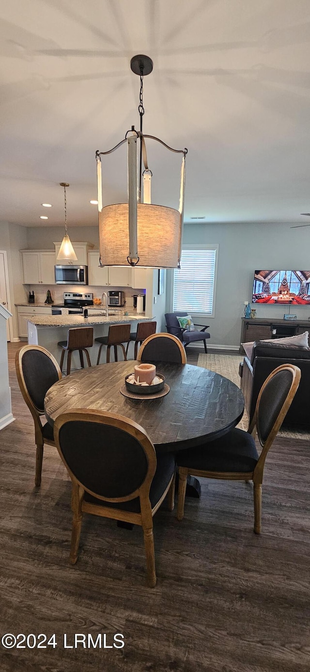 dining room with dark wood-type flooring and sink