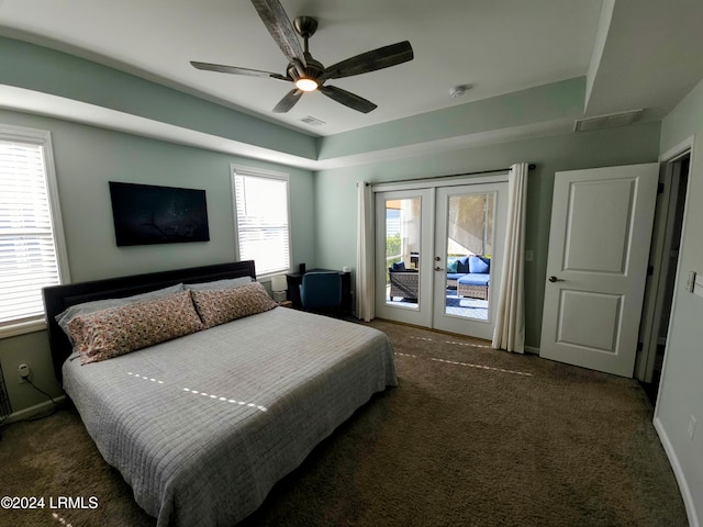 bedroom featuring french doors, a raised ceiling, dark carpet, ceiling fan, and access to exterior