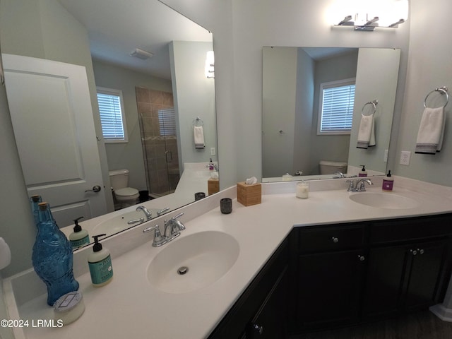 bathroom with plenty of natural light, toilet, an enclosed shower, and vanity