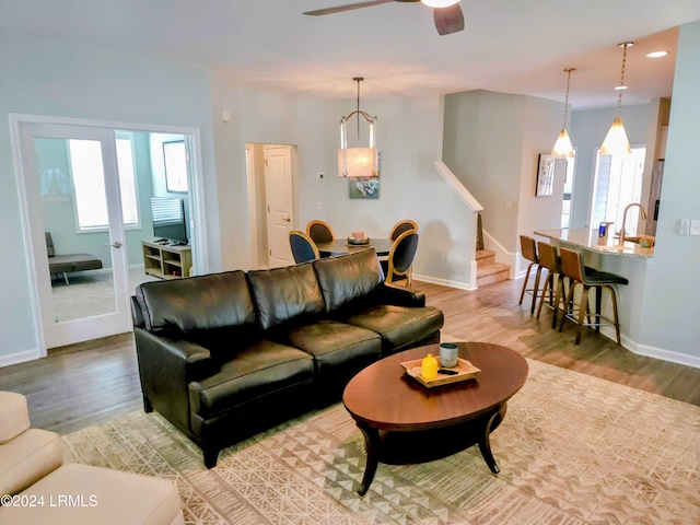 living room featuring sink, ceiling fan, and light hardwood / wood-style flooring