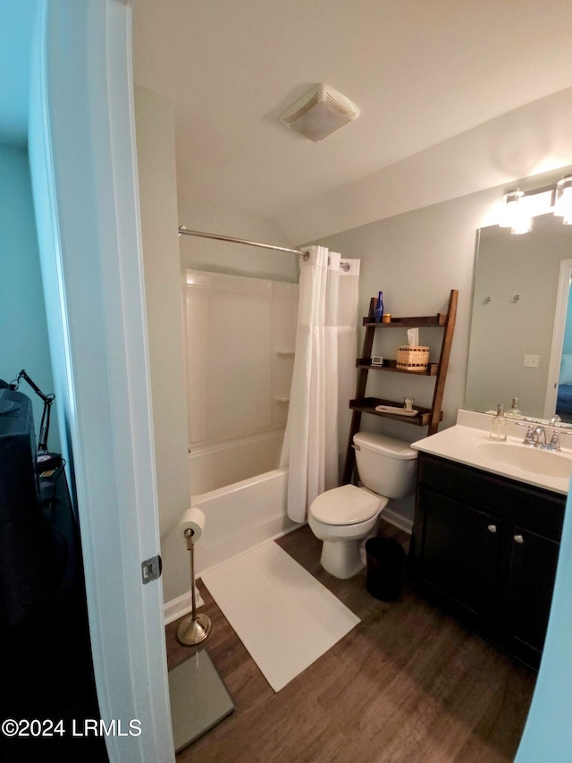 full bathroom featuring vanity, toilet, hardwood / wood-style floors, and shower / bath combo with shower curtain