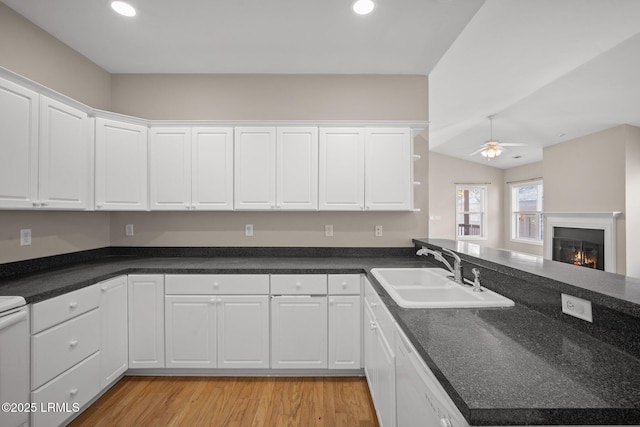 kitchen featuring sink, white cabinetry, light hardwood / wood-style flooring, white dishwasher, and ceiling fan