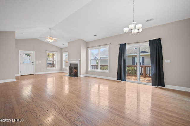 unfurnished living room featuring lofted ceiling, ceiling fan with notable chandelier, and light hardwood / wood-style floors