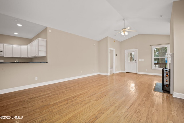 unfurnished living room with ceiling fan, vaulted ceiling, and light hardwood / wood-style flooring