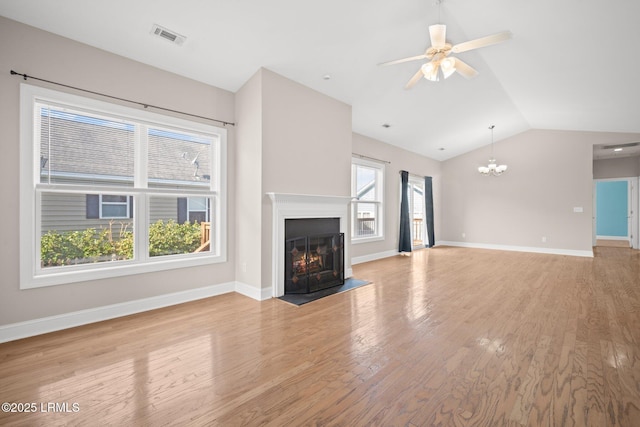 unfurnished living room featuring vaulted ceiling, ceiling fan with notable chandelier, and light hardwood / wood-style floors