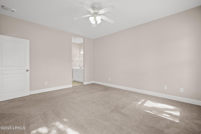 unfurnished bedroom with ceiling fan, light colored carpet, and ensuite bathroom