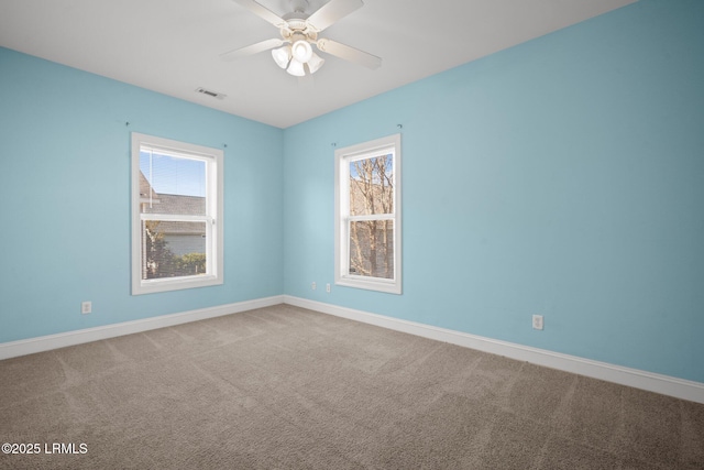 carpeted spare room featuring ceiling fan