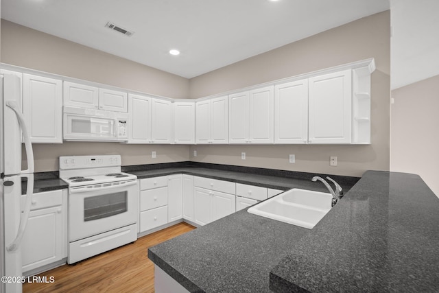 kitchen featuring sink, white cabinets, light hardwood / wood-style floors, kitchen peninsula, and white appliances