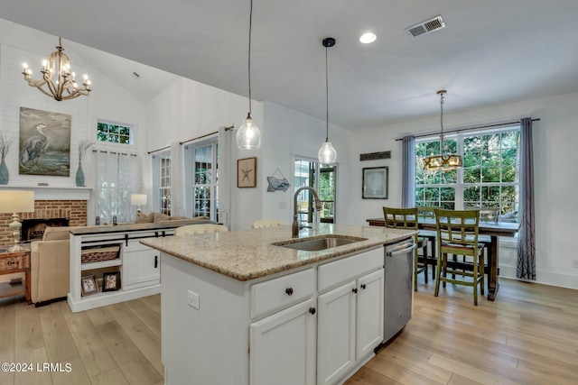 kitchen featuring sink, white cabinetry, a kitchen island with sink, light stone countertops, and stainless steel dishwasher