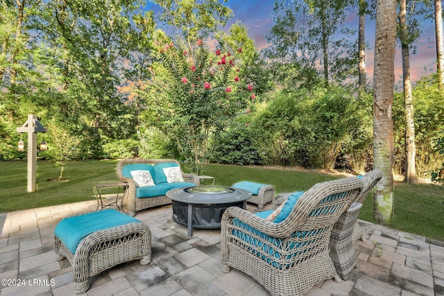 patio terrace at dusk with an outdoor living space and a yard