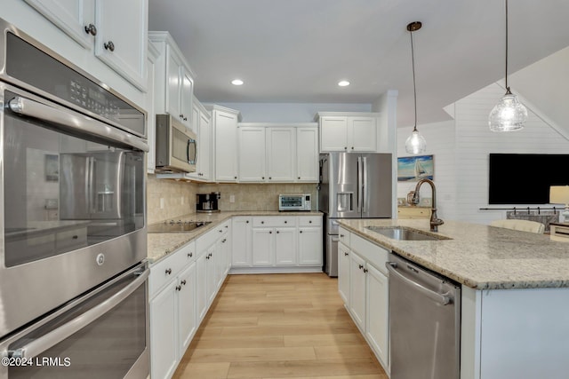 kitchen with stainless steel appliances, sink, and white cabinets