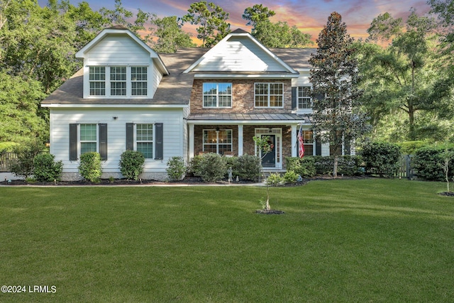 view of front facade with a porch and a lawn