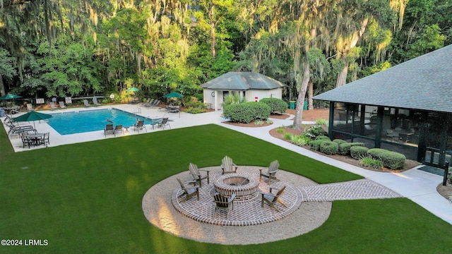 view of pool featuring an outbuilding, an outdoor fire pit, and a yard