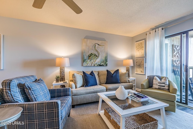living room featuring ceiling fan and a textured ceiling