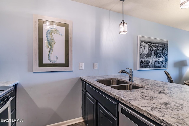 kitchen with light stone counters, sink, stainless steel dishwasher, and hanging light fixtures