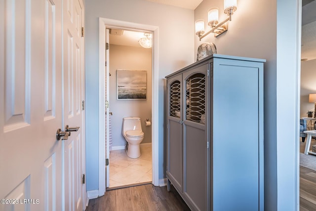bathroom with hardwood / wood-style flooring and toilet