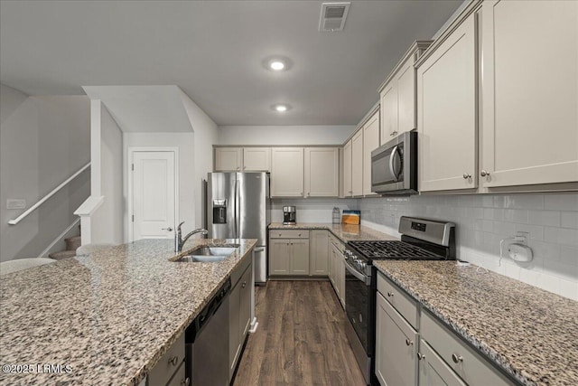 86 Slater St, Bluffton, SC 29909 - kitchen featuring appliances with stainless steel finishes, dark wood-style flooring, light stone countertops, and tasteful backsplash
