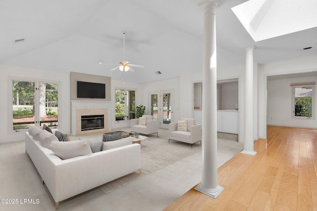 196 White Oaks Cir, Bluffton, SC 29910 - living room with ornate columns, a glass covered fireplace, lofted ceiling with skylight, and light wood-style floors