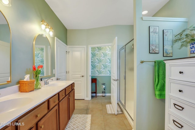 full bathroom with tile patterned floors, a stall shower, double vanity, and a sink