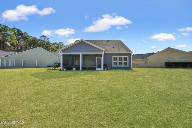 back of property with a lawn and a sunroom