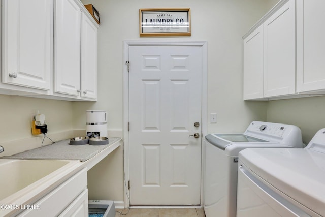 laundry room with washer and dryer, light tile patterned flooring, cabinet space, and a sink