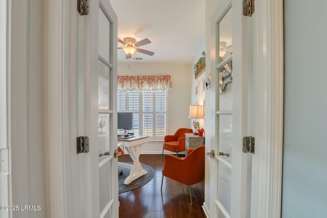 interior space featuring ceiling fan, baseboards, and wood finished floors