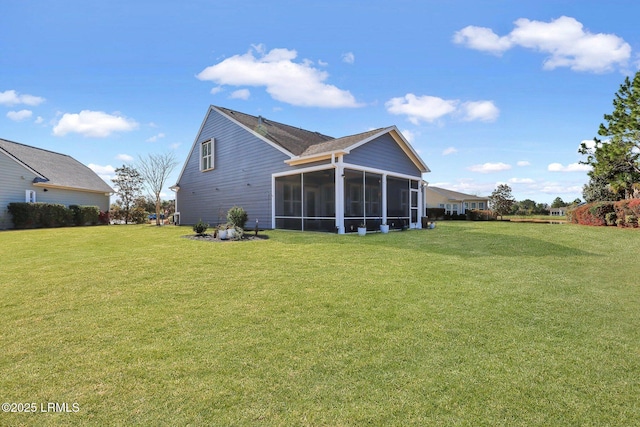 rear view of house with a lawn and a sunroom