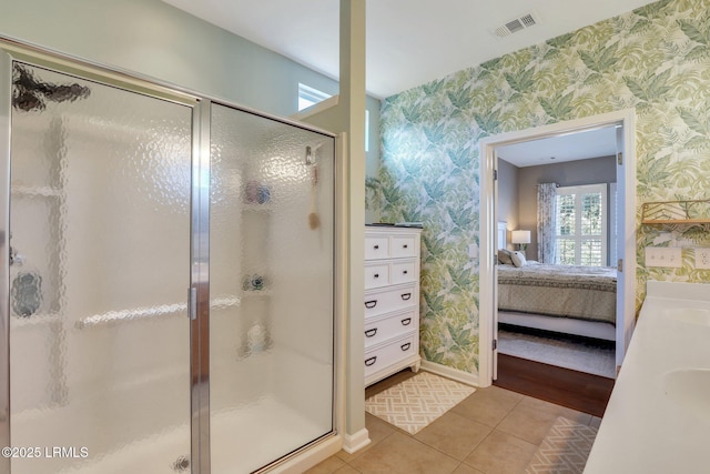 ensuite bathroom with visible vents, ensuite bathroom, wallpapered walls, a shower stall, and tile patterned flooring