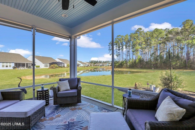 sunroom / solarium with ceiling fan and a water view