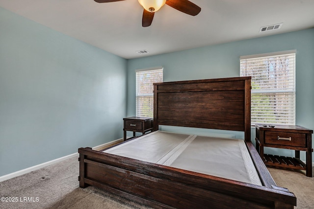 carpeted bedroom with visible vents, ceiling fan, and baseboards