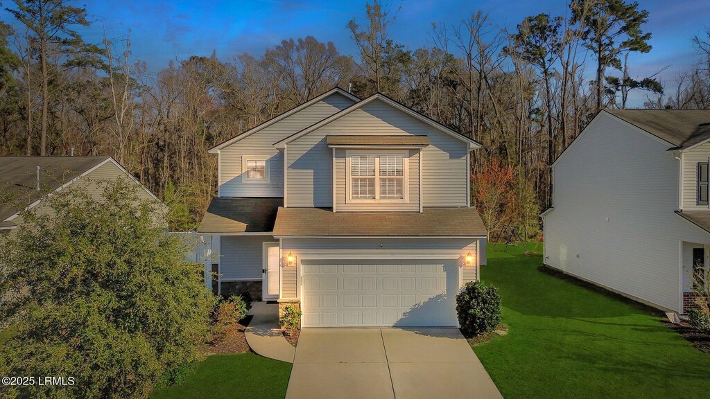17 Hager Rd, Bluffton, SC 29910 - view of front of property featuring a garage, a front yard, concrete driveway, and stone siding