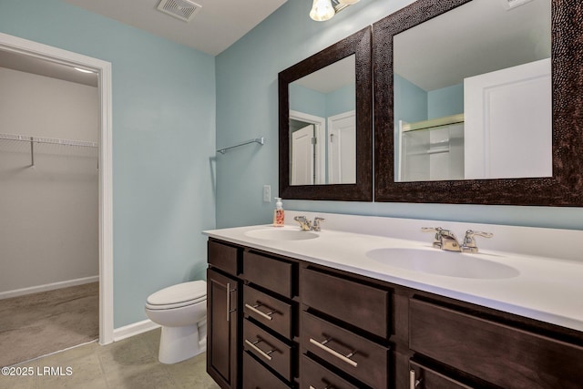 bathroom featuring visible vents, a sink, a shower stall, and toilet