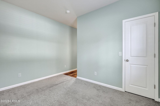 carpeted spare room featuring baseboards