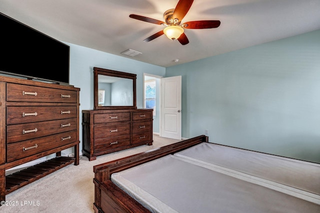 bedroom with light carpet, visible vents, and a ceiling fan