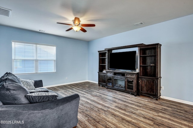 living area with dark wood-style floors, visible vents, and ceiling fan