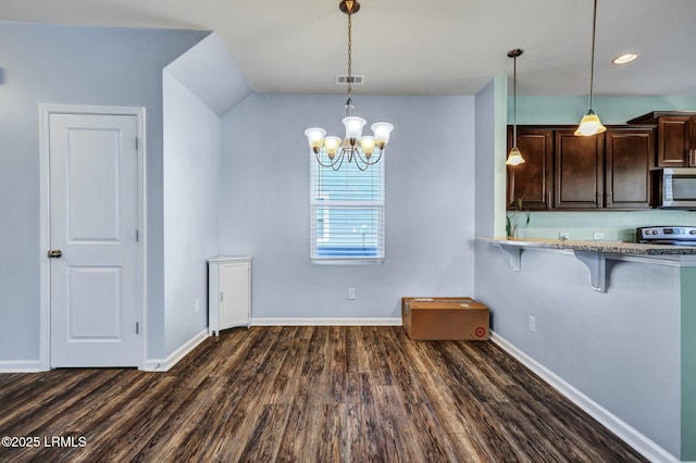 kitchen featuring a breakfast bar, dark wood finished floors, visible vents, appliances with stainless steel finishes, and baseboards