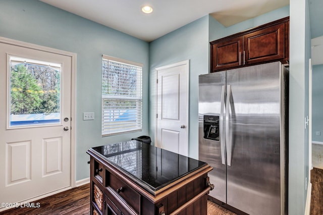 kitchen featuring plenty of natural light, stainless steel fridge, dark wood-style floors, and dark brown cabinets