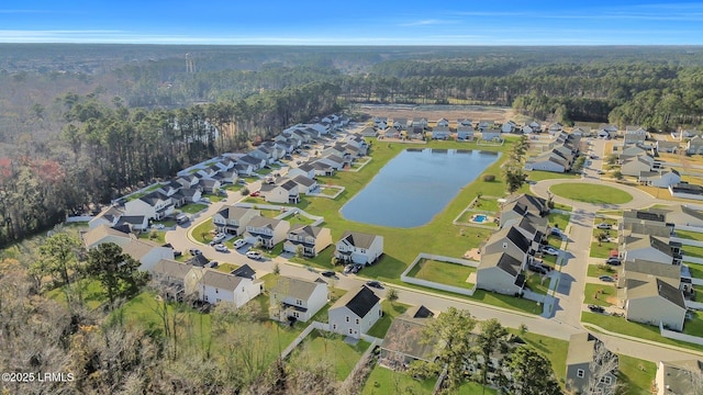 aerial view featuring a water view, a wooded view, and a residential view